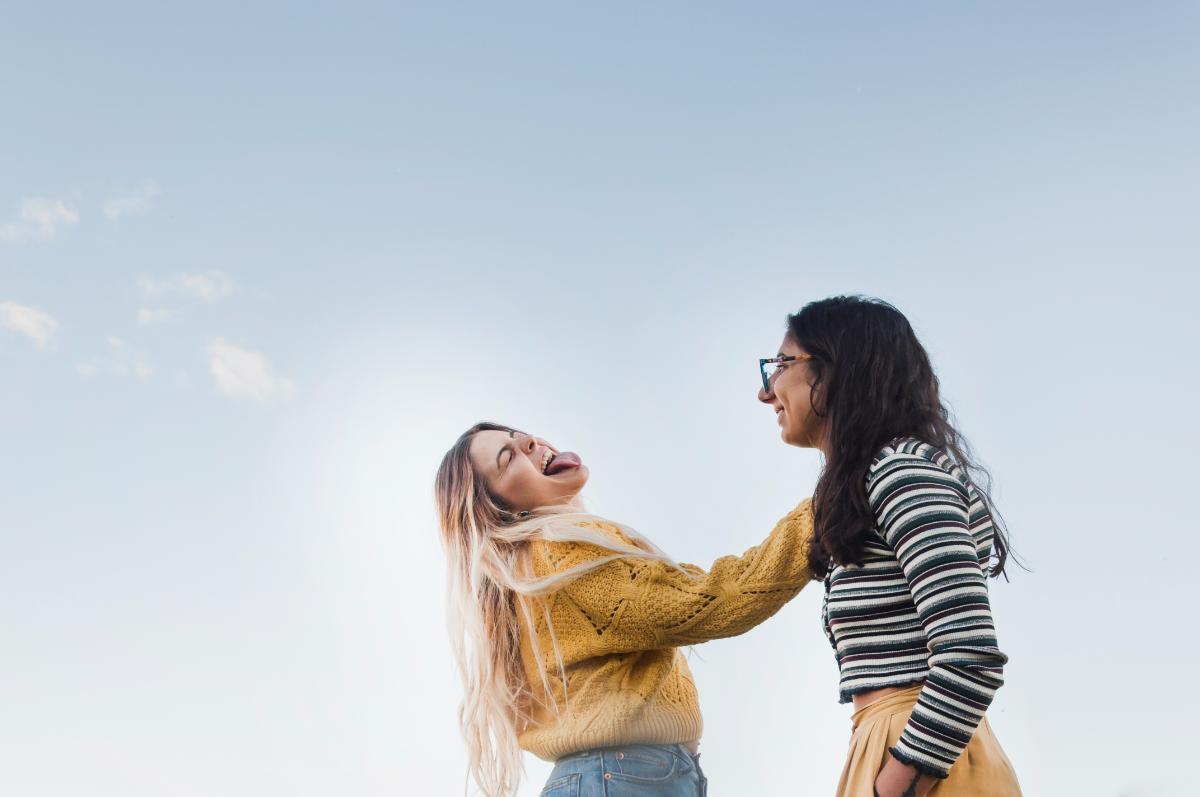 Dos personas riendo juntas al aire libre